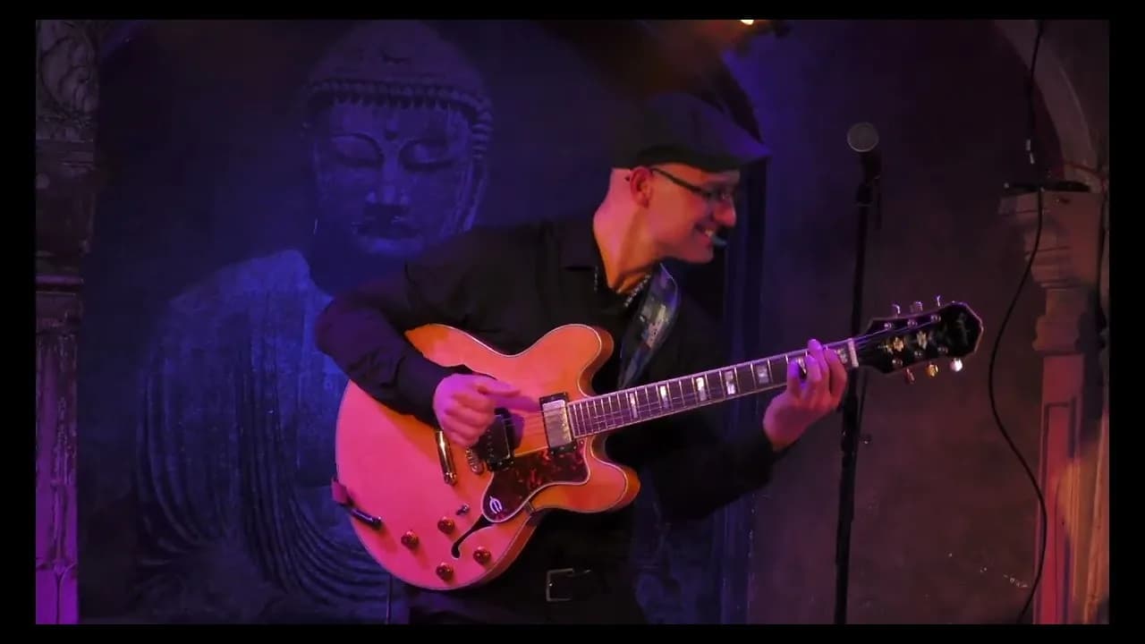 Pete Roth playing guitar in a Pete Roth Trio Trading Boundaries video.