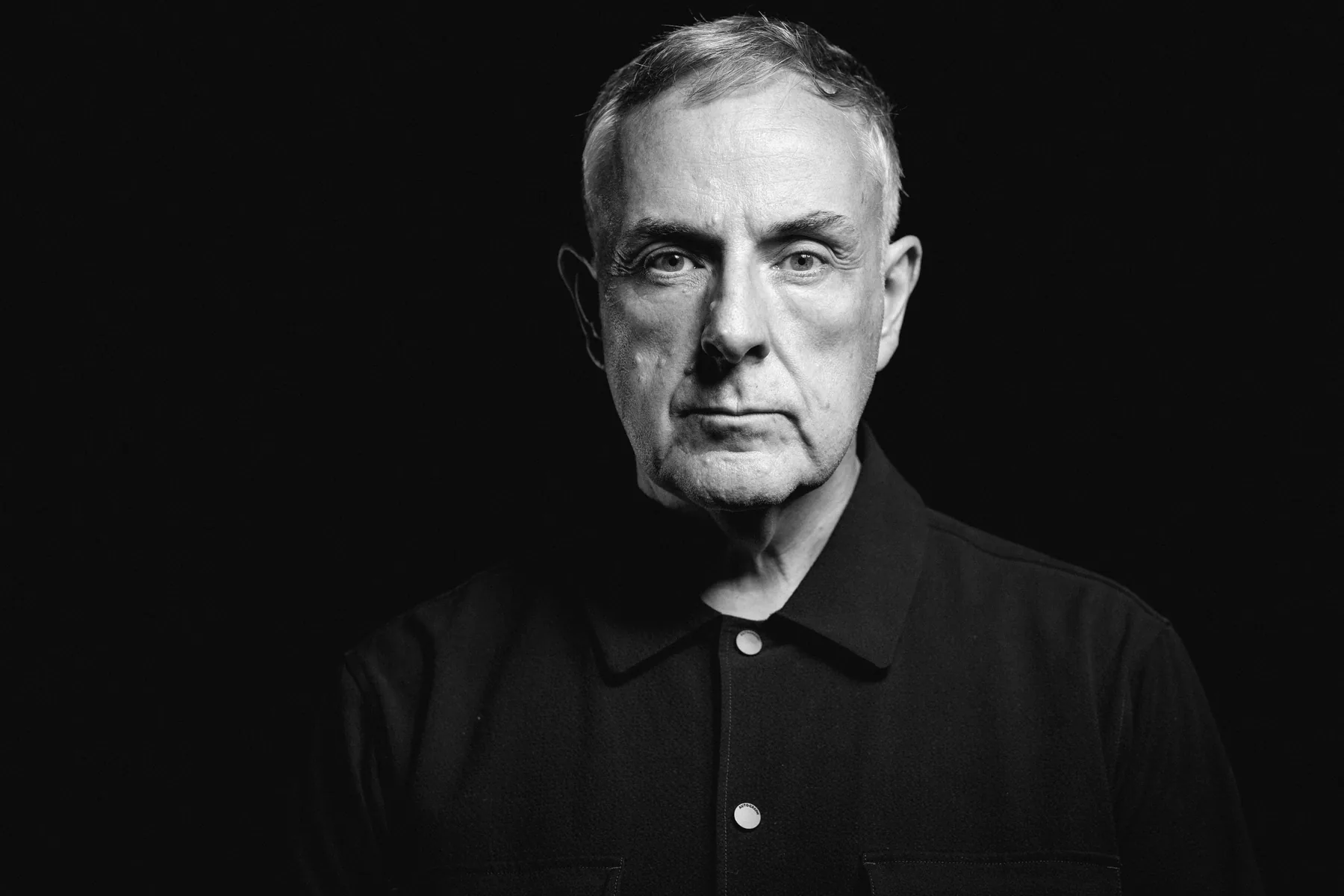 Black-and-white portrait of Mike Pratt against a dark background.